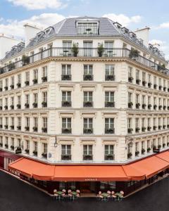 un grand bâtiment blanc avec un auvent rouge dans l'établissement Le Grand Mazarin, à Paris
