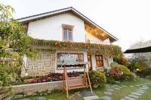 a white house with a bench in front of it at VANDA VIilla Garden trung tâm in Da Lat