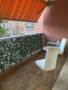 d'un balcon avec deux chaises, une table et une fenêtre. dans l'établissement Large Studio 907T near Monte Carlo Casino Monaco, à Monte-Carlo