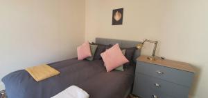 考文垂的住宿－Coventry Spacious Rooms In City，一间卧室配有带枕头的床铺和梳妆台