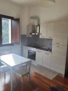Casa Sofì في Zagarolo: مطبخ بطاولة بيضاء وطاولة وكراسي