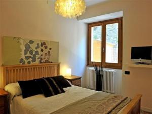 a bedroom with a bed and a window and a chandelier at Lenno Centrale in Lenno