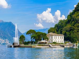 una fuente en medio de un lago con un edificio en Lenno Centrale, en Lenno