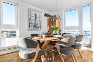 a dining room with a wooden table and chairs at Hafen Loft in Olpenitz
