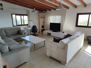 a living room with couches and a flat screen tv at Sunset and oceanview 1 bedroom apartment with shared pool in Salobre