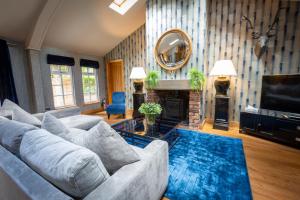 a living room with a couch and a mirror at The Hollies Forest Lodges in Cuddington
