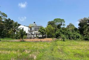 a house in the middle of a field at Jas - Sri Lankan Villa in Polgasowita