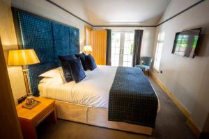 A bed or beds in a room at The Hollies Forest Lodges