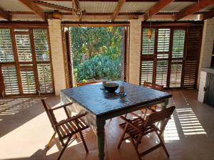 a dining room with a blue table and chairs at Chillilabombwe in Pringle Bay