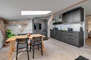 cocina con mesa de madera y sillas en Lion Apartments - Modern Attic en Sopot