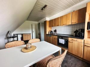 eine Küche mit einem weißen Tisch und Stühlen in der Unterkunft DG-Wohnung mit sonnigem Balkon in Marburg an der Lahn