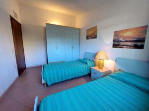 a bedroom with two beds and a lamp in it at Residence Abba Urci in Tertenìa +250 photos