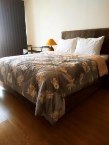a bed with a blanket with flowers on it at DeAr Caspian Apartment in Surabaya