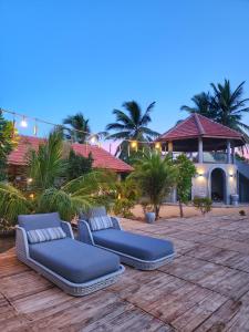 two blue beds on a patio in front of a house at Arasi Resort in Kalpitiya