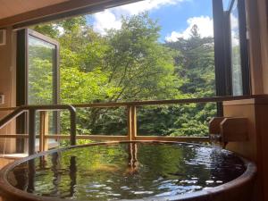 a bath tub in a room with a window at 日光ガーデンホテル in Nasushiobara