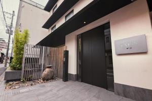 a black door of a building with a sign on it at KABIN Koji in Kyoto