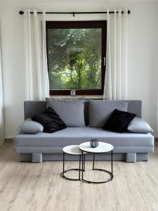 uma sala de estar com um sofá e uma mesa em Modernes Apartment mit 180° Bergblick em Buchenberg
