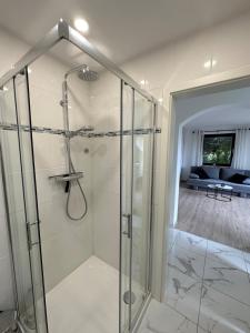 a bathroom with a shower with a glass enclosure at Modernes Apartment mit 180° Bergblick in Buchenberg