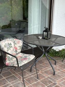 a table and a chair on a patio at Modernes Apartment mit 180° Bergblick in Buchenberg