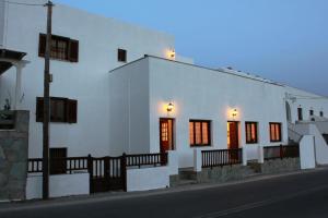 a white building with a row of windows on a street at Violetta in Ios Chora