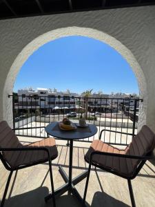 a patio with a table and chairs on a balcony at Papho's Mare Apts in Paphos