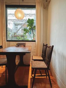 una mesa y una silla en una habitación con ventana en 小仙肉包棟民宿, en Miaoli