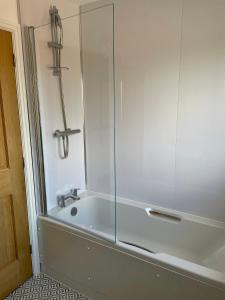 a bathroom with a tub with a glass shower at The Old Dairy in Chappel