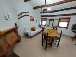 a living room with a table and a couch at Casa Rural Nueva Araceli in Oliete