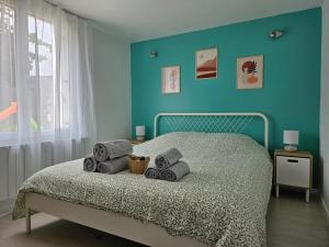 Schlafzimmer mit einem Bett mit blauer Wand in der Unterkunft T2 calme et cozy, proche transports in Aulnay-sous-Bois