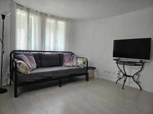 ein Wohnzimmer mit einem Sofa und einem Flachbild-TV in der Unterkunft T2 calme et cozy, proche transports in Aulnay-sous-Bois