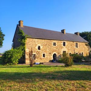 a large brick building with a grassy yard at Luxury Farmhouse Brittany in Plénée-Jugon