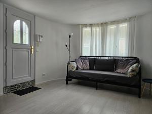 ein Wohnzimmer mit einem Sofa vor einem Fenster in der Unterkunft T2 calme et cozy, proche transports in Aulnay-sous-Bois