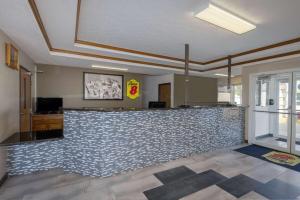 a lobby with a bar with a tile wall at Super 8 by Wyndham De Soto in De Soto