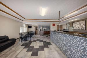 a restaurant with a bar with a couch and chairs at Super 8 by Wyndham De Soto in De Soto