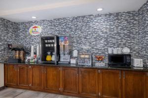 a bar in a restaurant with a brick wall at Super 8 by Wyndham De Soto in De Soto