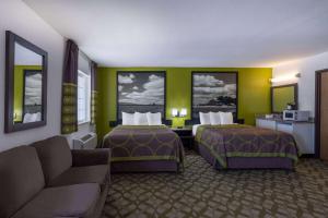 um quarto de hotel com duas camas e um sofá em Super 8 by Wyndham De Soto em De Soto