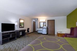 a large hotel room with a bed and a television at Super 8 by Wyndham De Soto in De Soto