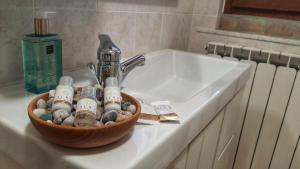 un lavandino in bagno con ciotola di rocce accanto a un lavandino di Spicchio di Luna - Casa Vacanze ad Albiano