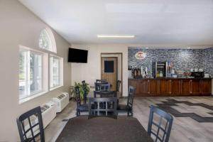 a living room with a table and chairs and a bar at Super 8 by Wyndham De Soto in De Soto