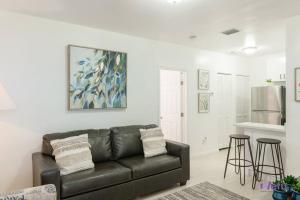 sala de estar con sofá de cuero y 2 taburetes en Hidden Gem Apt/near downtown Miami & Brickell, en Miami