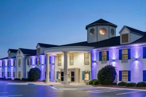 a large white building with purple lights on it at Days Inn by Wyndham Shallotte in Shallotte