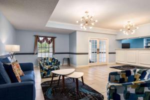 a living room with blue walls and a table and chairs at Days Inn by Wyndham Shallotte in Shallotte