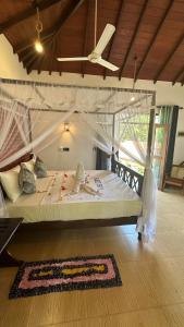 - une chambre avec un grand lit dans l'établissement Dosemo Cabana, à Induruwa