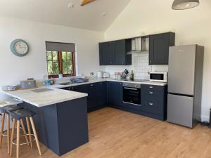 a kitchen with blue cabinets and a white refrigerator at The Old Dairy in Chappel