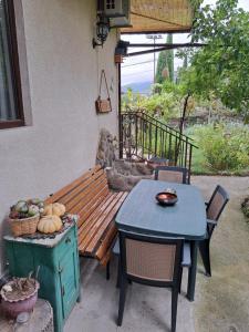 a wooden bench sitting next to a table and a table and chairs at Niki in Mtskheta