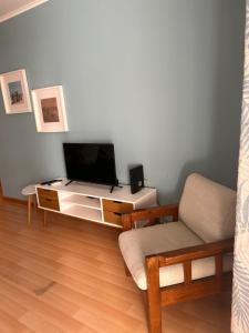 a living room with a tv and a couch at Beach House Carmen 2 in Monte Gordo