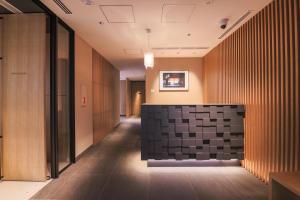 a hallway of a building with a black and white tile wall at KABIN Koji in Kyoto