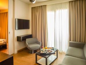 un soggiorno con un divano e una poltrona di Novotel Salerno Est Arechi a Salerno