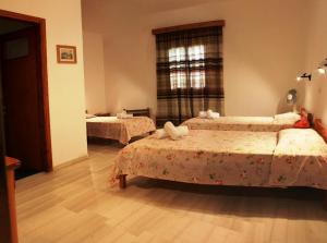 een slaapkamer met 2 bedden en een raam bij Violetta in Ios Chora