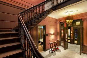 a spiral staircase in a home with red walls at Hotel Nassau Breda, Autograph Collection in Breda